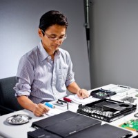 Sony engineering director Yasuhiro Ootori looks over a PlayStation 4 after taking it apart, piece by piece.
