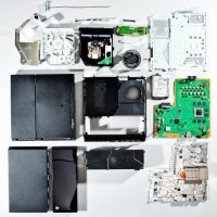 The PS4's internal parts, after the teardown. The motherboard is the large green piece on the right.